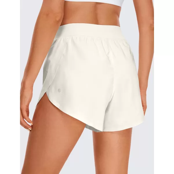 CRZ YOGA Mid Waisted Dolphin Athletic Shorts for Women Lightweight High Split Gym Workout Shorts with Liner Quick DryMilky White